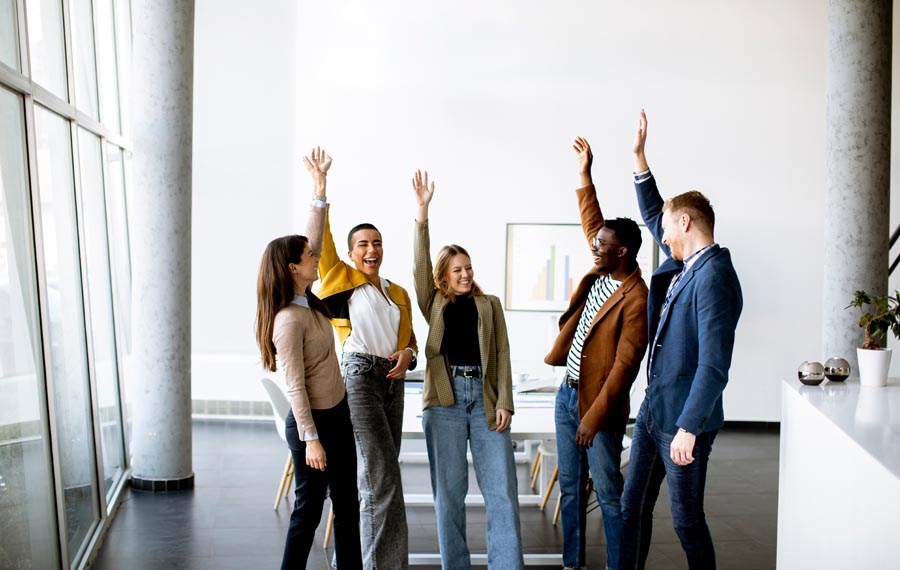 Young creative team putting their hands together in the modern o